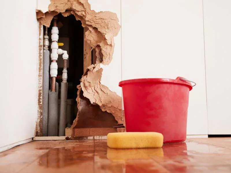 A plumber cutting out a failed section of copper supply pipe