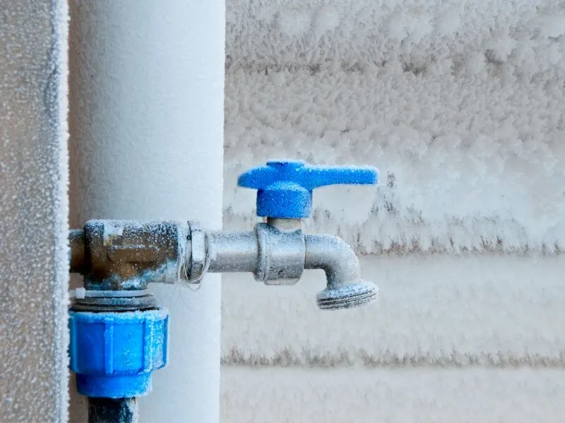 Frost forming on an exposed water pipe in an unheated basement