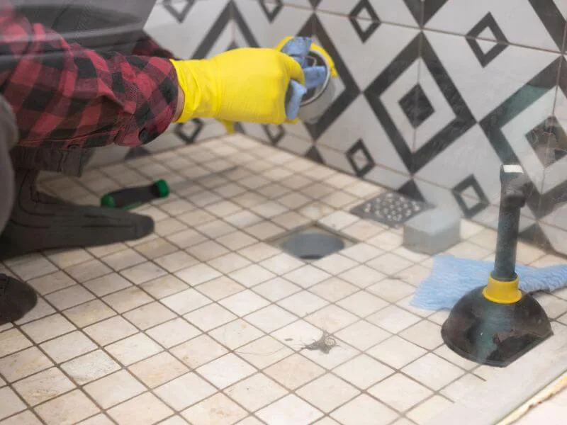 A plumber resetting a toilet onto a new wax seal