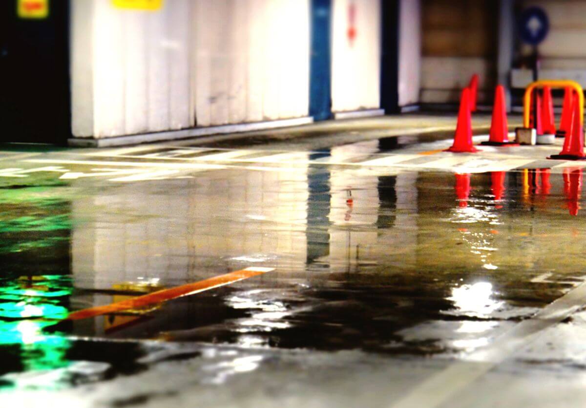 Standing water across a basement floor beside a floor drain