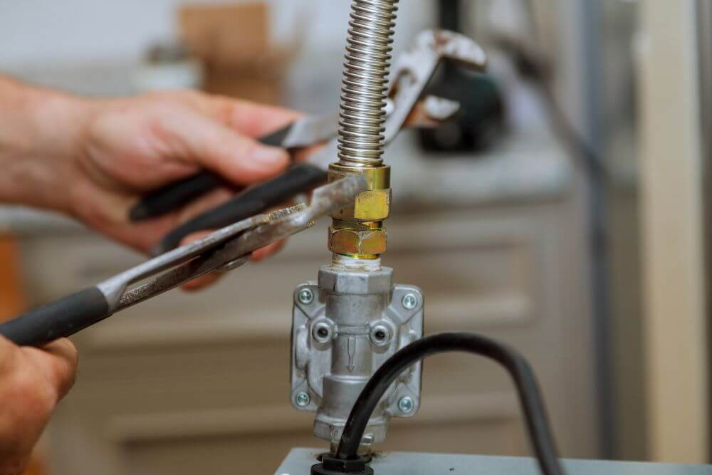 A gas detector being used along a black iron gas line